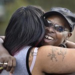 Velma Aiken, the paternal grandmother of Kamiyah Mobley, who was kidnapped as an infant 18 years ago, gets a congratulatory hug from a family member after Mobley was found safe Friday, Jan. 13, 2017, in Jacksonville, Fla. (Will Dickey /The Florida Times-Union via AP)