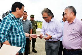 PRESIDENT Duterte hands over a check for R192.5 million to Southern Philippines Medical Center chief Dr. Leopoldo Vega at the Tactical Operations Group 11 in Sasa, Davao City. The check is the first tranche of the R385 million needed to improve the facilities of the SPMC. (Presidential photo)