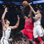 Chicago Bulls guard Dwyane Wade (3) goes to the basket past Brooklyn Nets center Brook Lopez (11) and guard KJ McDaniels (AP Photo/Mary Altaffer)