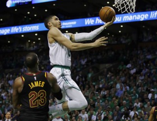Boston Celtics forward Jayson Tatum (0) goes to the basket over Cleveland Cavaliers forward LeBron James. (AP Photo/Charles Krupa)