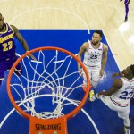 Los Angeles Lakers' LeBron James (left) goes for a shot as Philadelphia 76ers' Ben Simmons and Jimmy Butler (right) look on during their NBA match on Sunday. The 76ers won, 143-120. (AP)